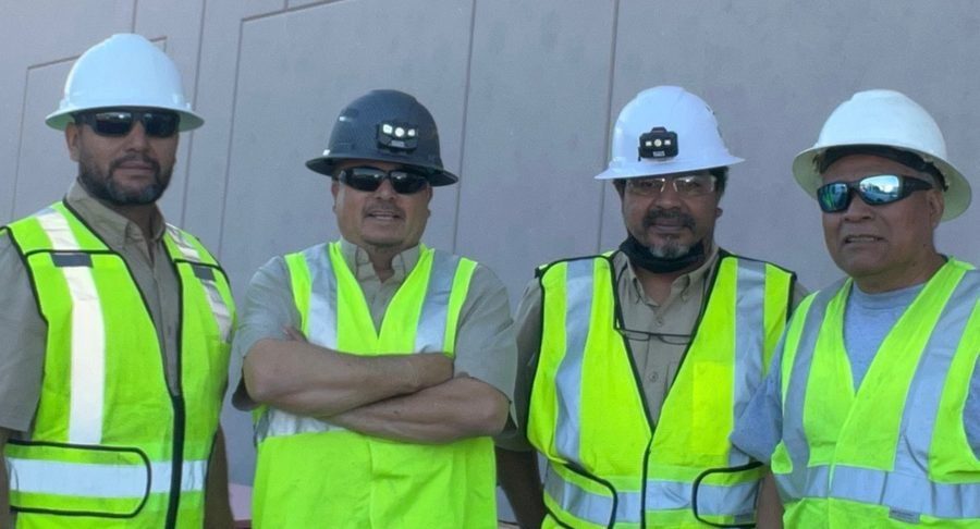 Eco Electric team posing for a photo in hardhats and reflective vests.