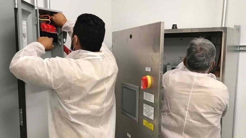 Eco Electricians conducting electrical repairs on panels and transfer switches.