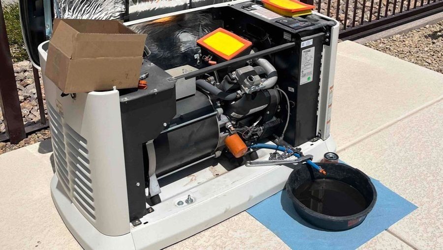 Outdoor standby generator with the cover removed, showing internal engine components during maintenance