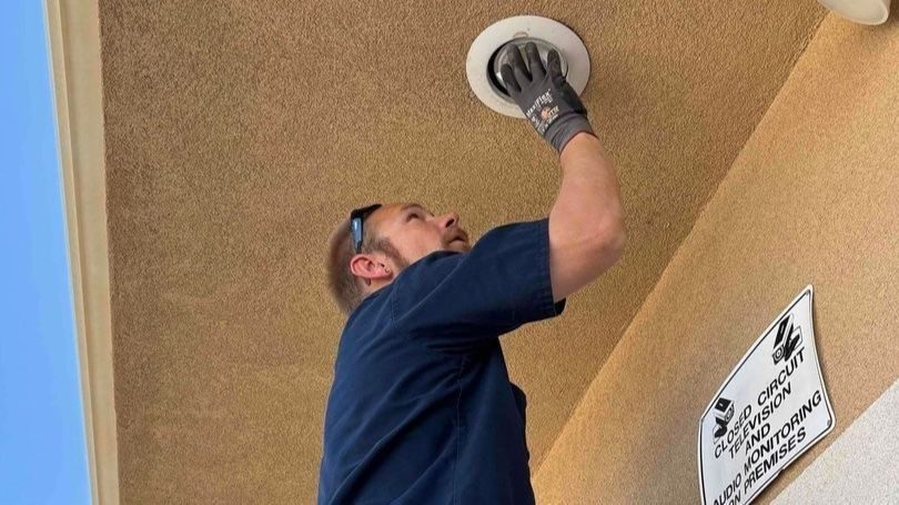 Property manager screwing in light bulb.